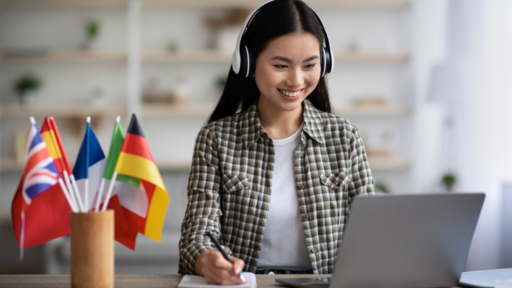 adult learner with her laptop and many countries flags on her desk